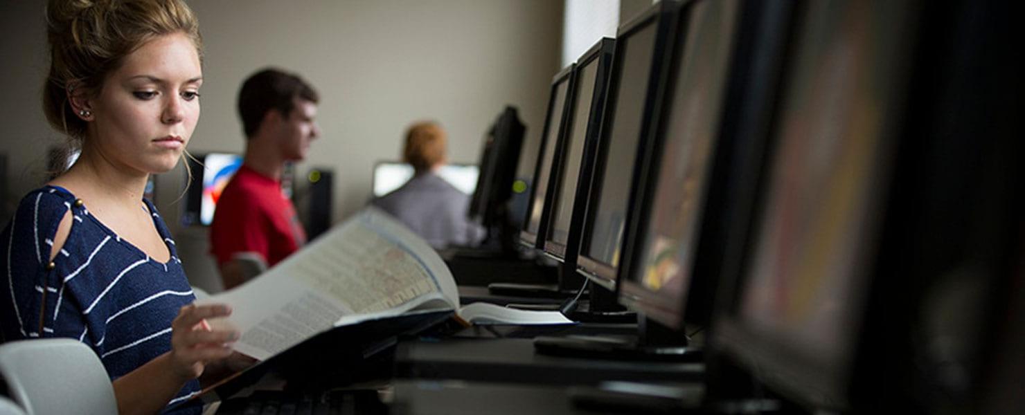 MU student in classroom setting working at a computer.